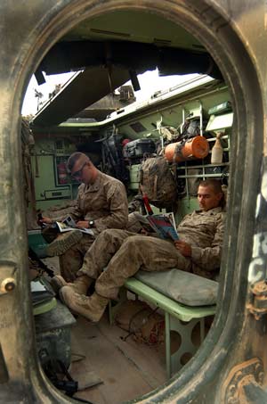 CAMP FALLUJAH, Iraq – LCpl. Stephen Sensing, left, from Nashville, Tenn., and Sgt. Matthew Starr, Richmond, Minn., from 1st Platoon, 2nd Amphibious Assault Vehicle Company, 2nd Marine Division kick back prior to departing on an evening patrol Nov. 5.  Photo by: Chief Warrant Officer 2 Craig J. Shell